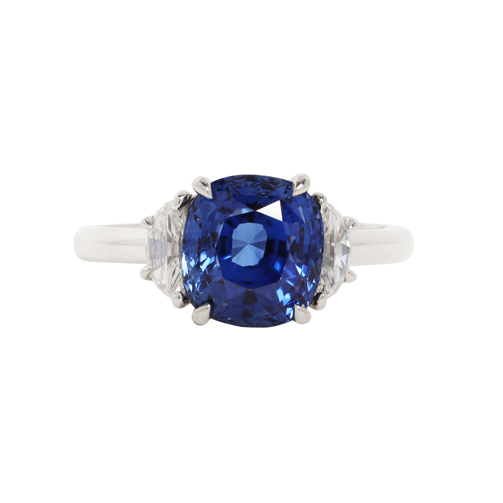 4.0 carat cushion cut blue sapphire center gemstone flanked by two half-moon diamonds in a platinum setting
