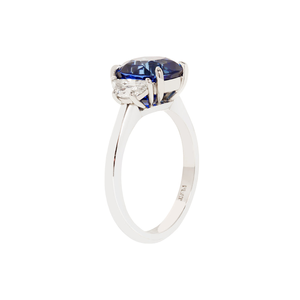4.0 carat cushion cut blue sapphire center gemstone flanked by two half-moon diamonds in a platinum setting, side view