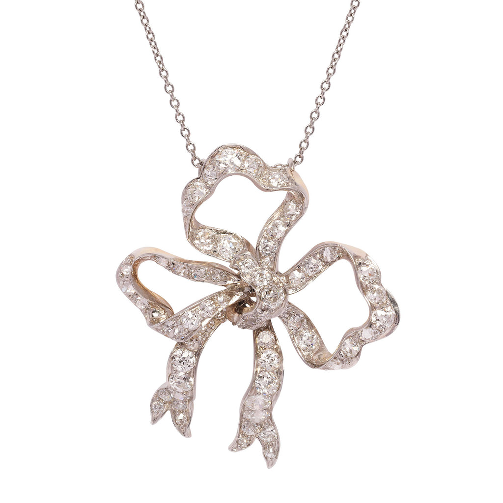 Front view of Edwardian diamond bow pendant in platinum with pavé old mine–cut diamonds on cable chain.