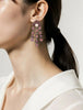On model view of 18K gold chandelier earrings with pink sapphires, rose-cut diamonds, and pearls.