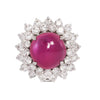 Front view of a platinum ring featuring a no-heat Burmese cabochon pink sapphire encircled by sparkling diamonds.