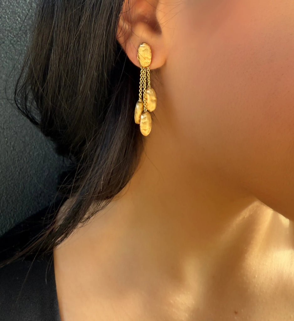 Siviglia gold earrings by Marco Bicego on model with dark hair.