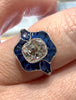 Antique-style Old Mine Cut diamond and sapphire ring shown on model’s hand.