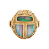 18K gold Egyptian Revival scarab ring by Opex with black opal inlay, bezel-set diamonds, and ribbed tapered shank.
