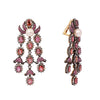 Side angle showing tiered pink sapphire and rose-cut diamond chandelier earrings with pearl tops.