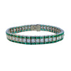 Platinum bracelet with a central row of European-cut diamonds bordered by two rows of square emerald gemstones.