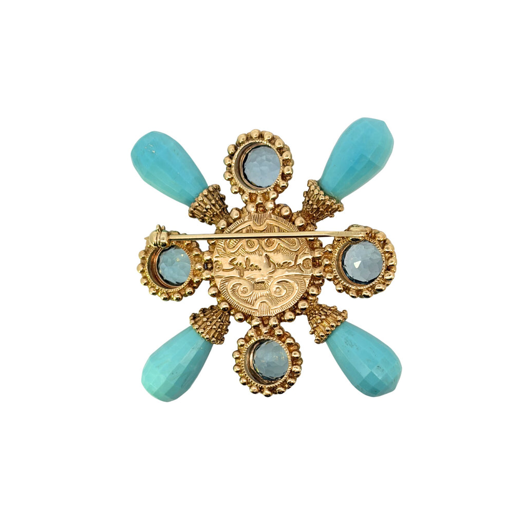 Reverse of a Stephen Dweck gold brooch showing the pin fastening, decorative back, turquoise briolettes and blue topaz settings.