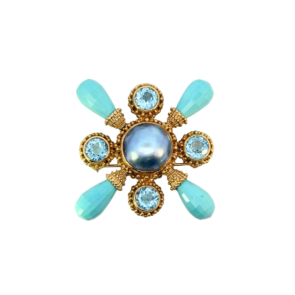 Stephen Dweck gold brooch with a gray mabé pearl center, four round blue topaz gemstones and four faceted turquoise briolettes.