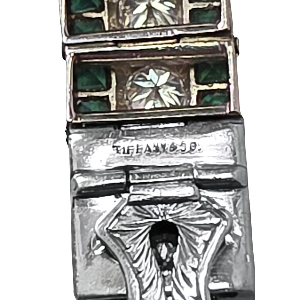 Close-up of the bracelet’s Tiffany-marked safety clasp, showing the reverse of the diamond and emerald links.