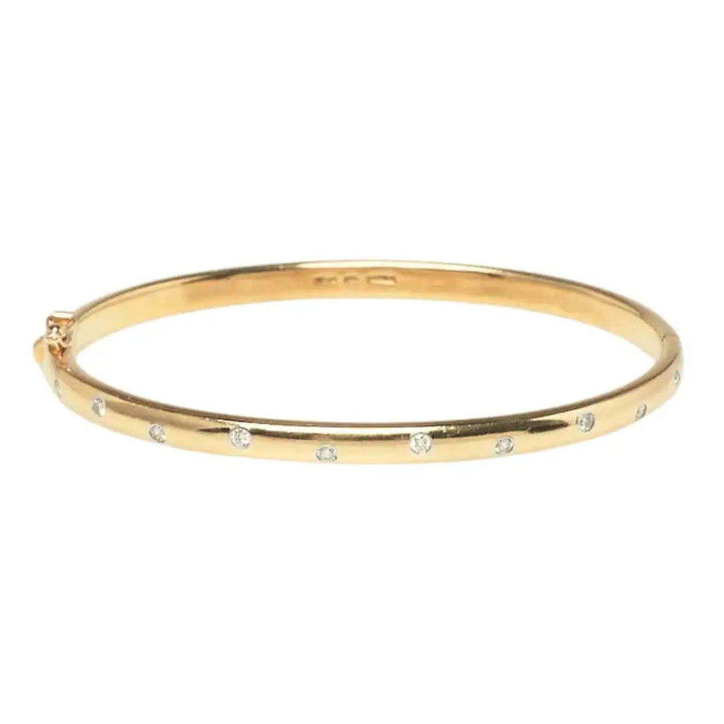 Front view of a Tiffany & Co. Etoile bangle featuring flush-set round brilliant diamonds in platinum bezels on 18k gold.