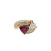 Front angled view of a trillion ruby and diamond bypass ring with opposing triangular gemstones and sweeping pavé diamond shoulders.