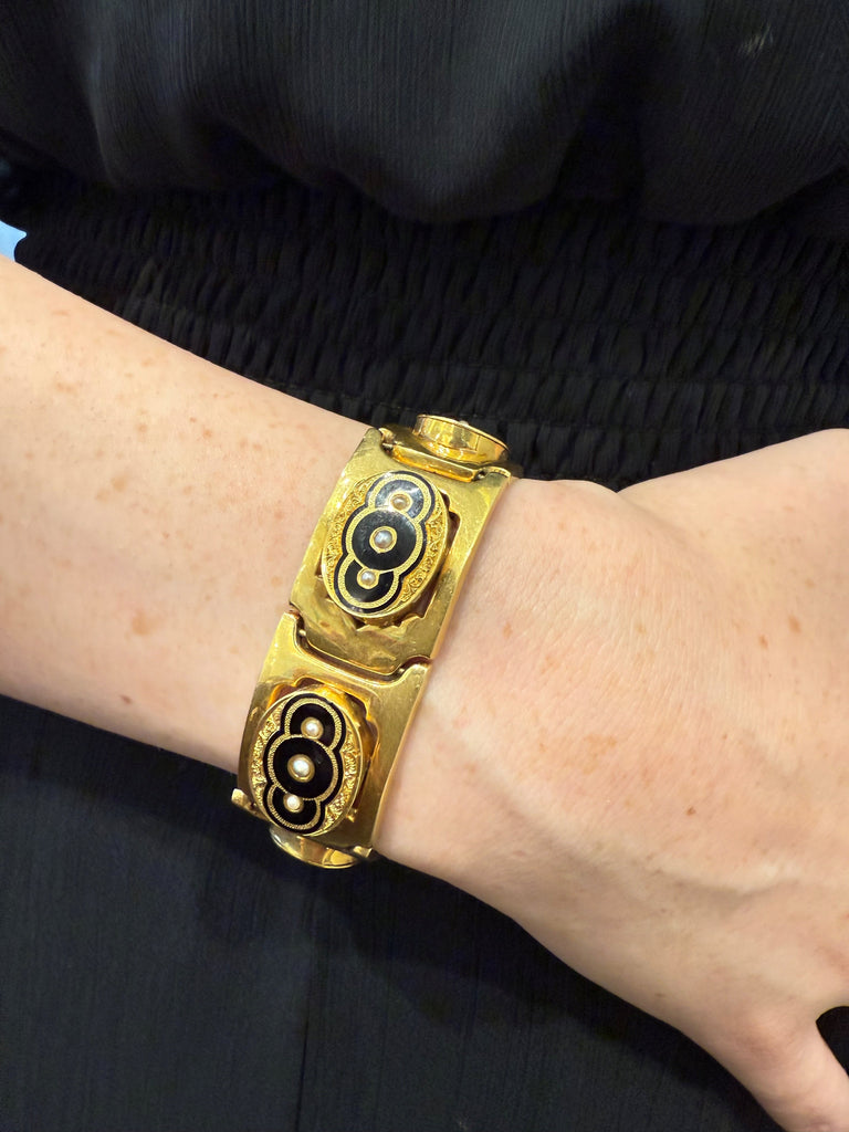 Victorian 18K yellow gold black enamel bracelet with natural half pearls worn on wrist