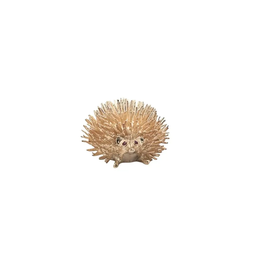 Front view of a vintage 14K yellow gold hedgehog pin featuring textured quills and ruby-set eyes.