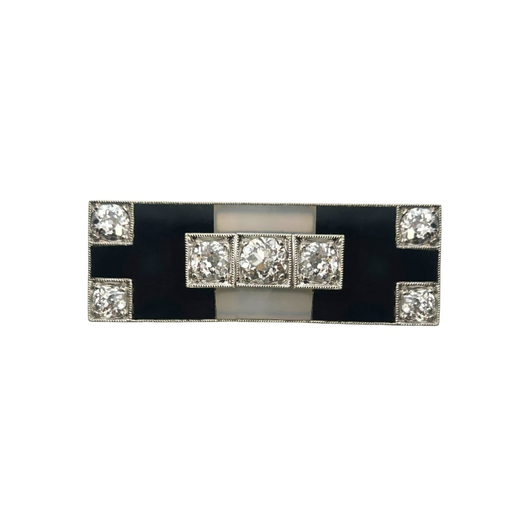 Rectangular Art Deco brooch with white and black onyx panels and seven old European–cut diamonds framed in milgrain, circa 1920s.