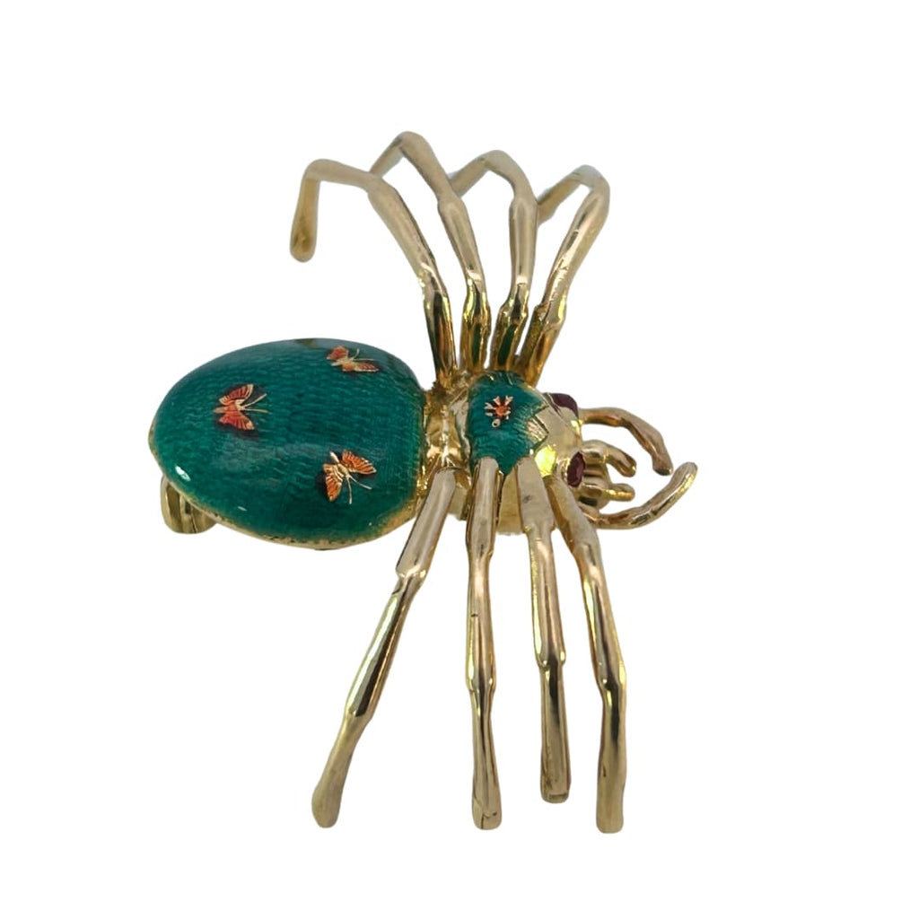 Side view of the enamel spider brooch showing curved gold legs and detailed enamel pattern.