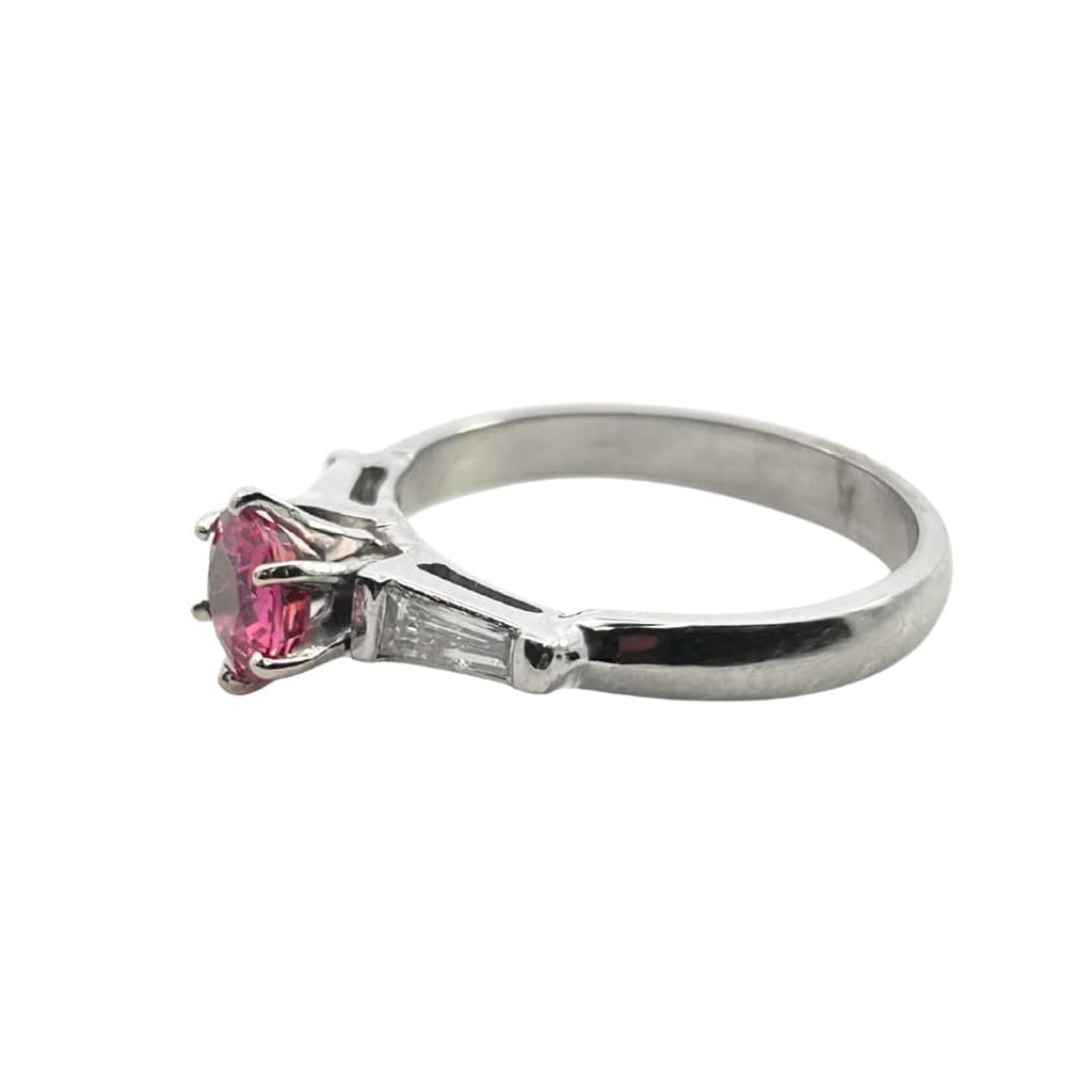 Estate platinum ring with 0.84ct round pink sapphire flanked by tapered baguette diamonds totaling ~0.30ct.