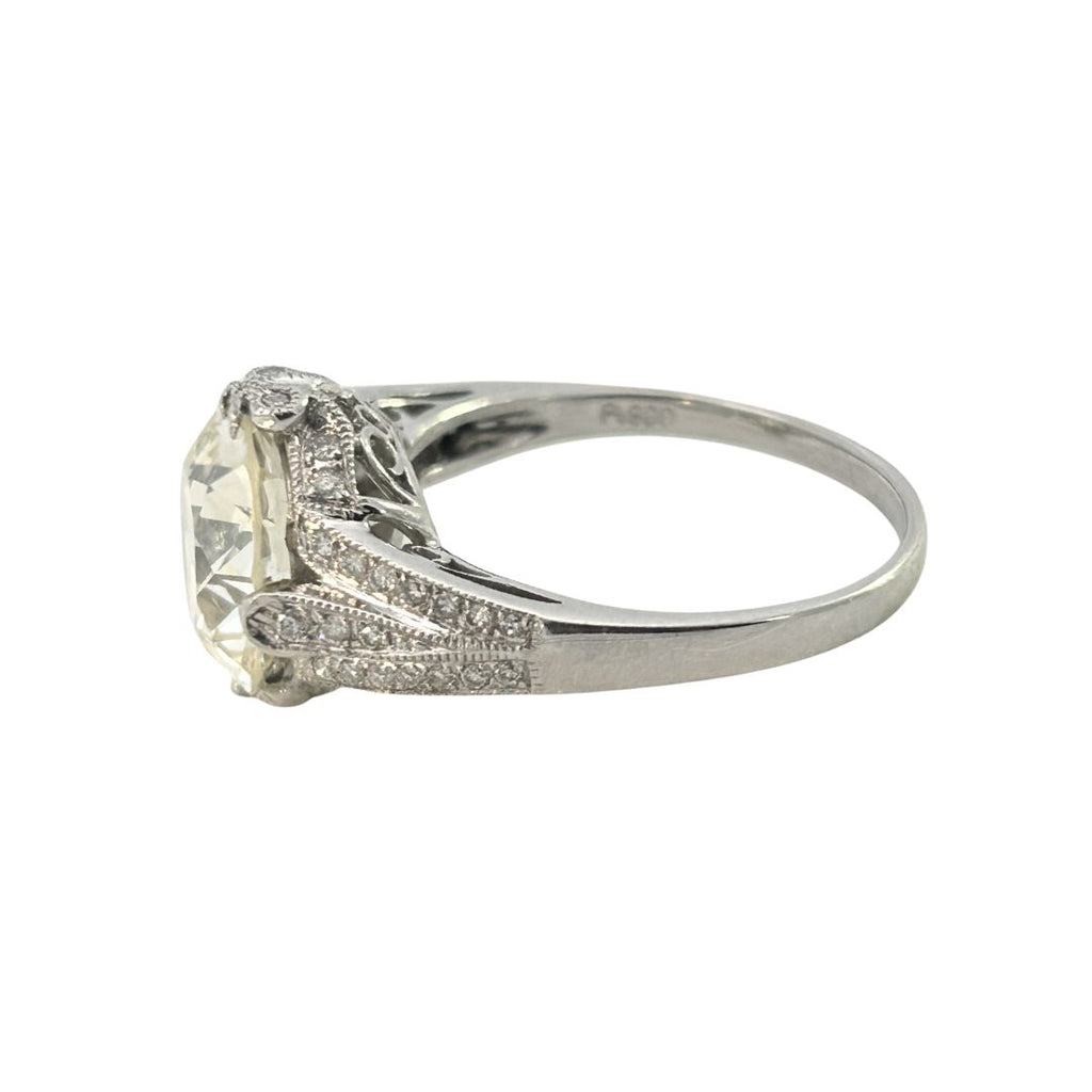 Platinum engagement ring showing graduated diamond shoulders rising toward a compass-set diamond