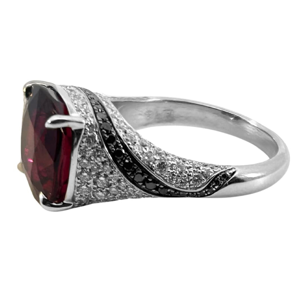 18k white gold rubellite and diamond cocktail ring with black diamond swirl accents and 5.35ct cushion-cut rubellite center.
