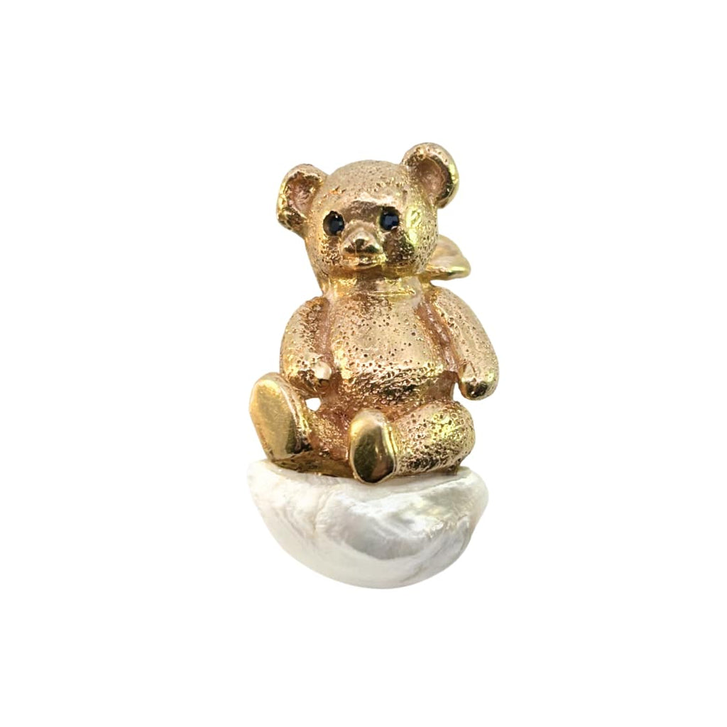 Front view of William Ruser teddy bear brooch in 14k yellow gold with sapphire eyes seated on an American freshwater pearl.